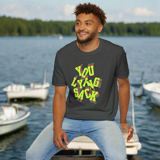 Man wearing a dark gray t-shirt with colorful text sitting on a white stool against a white background