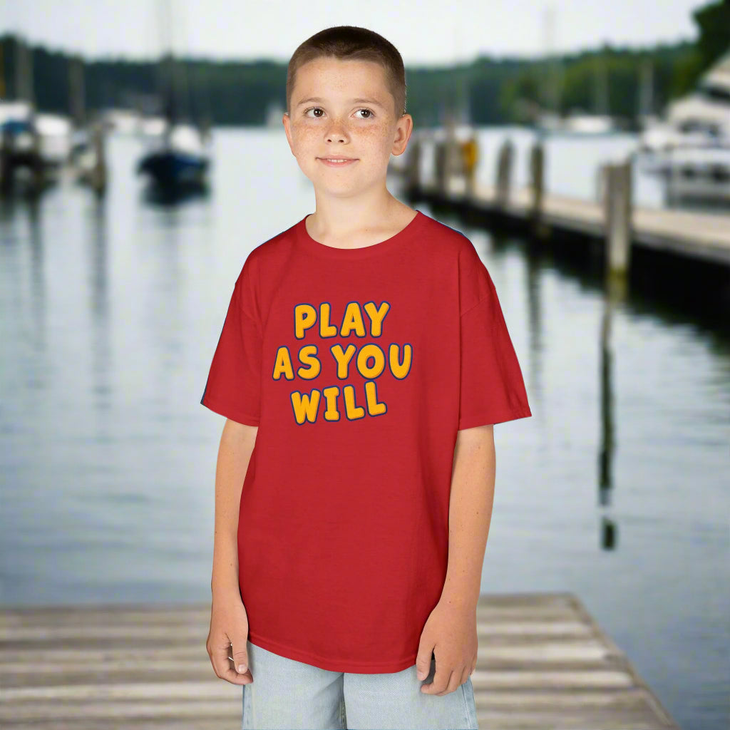 Child wearing a red t-shirt with 'Play As You Will' text on a white background