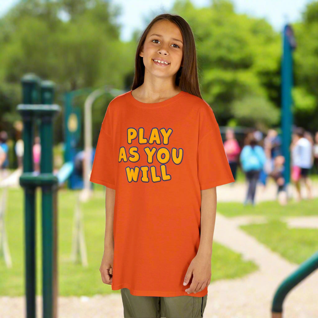 Child wearing an orange t-shirt with 'Play as You Will' text on a white background
