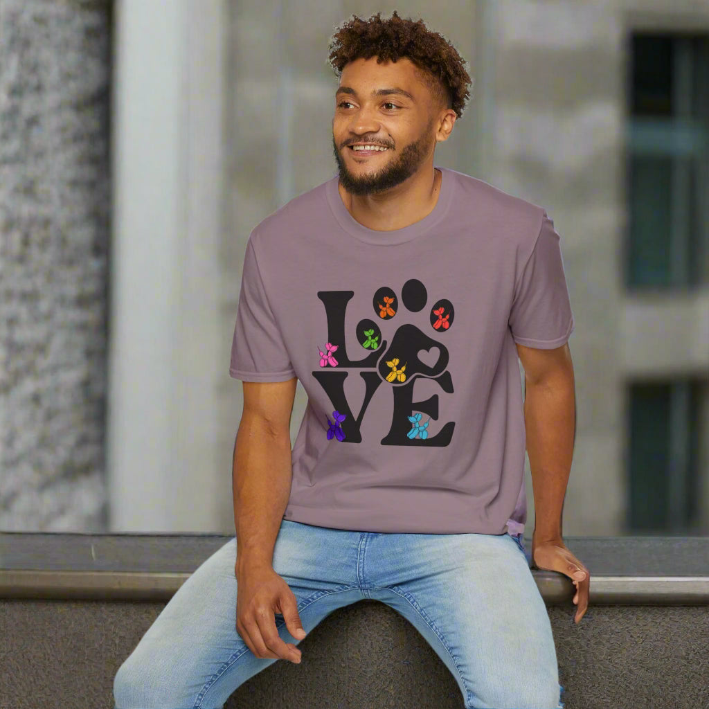 Man wearing a purple t-shirt with a colorful 'LOVE' design sitting on a white stool.