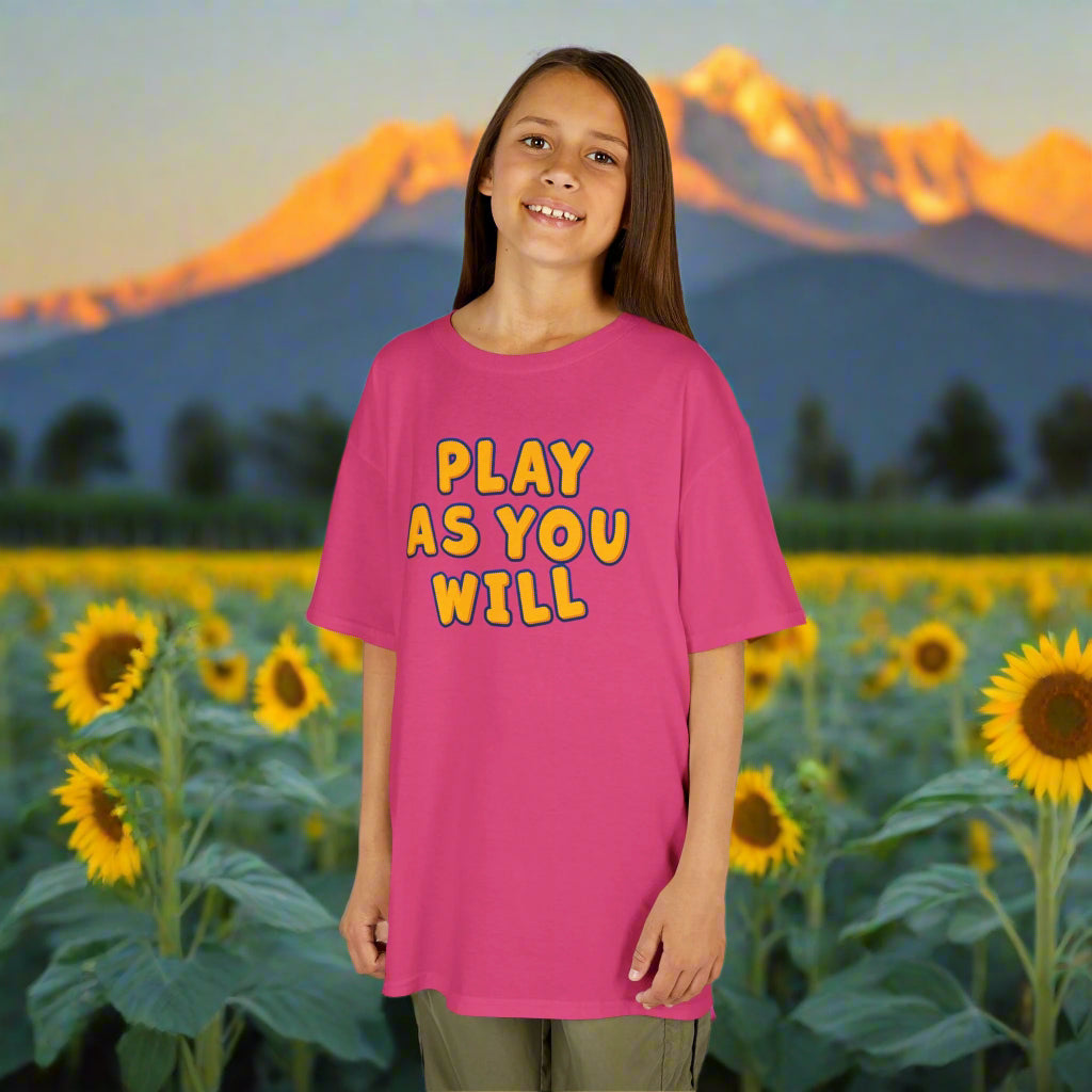 Young girl wearing a pink t-shirt with 'Play as You Will' text on a white background