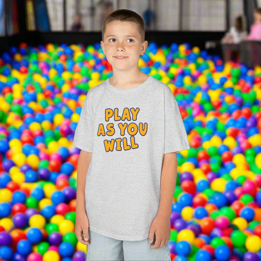 Child wearing a gray t-shirt with 'Play as You Will' text on a white background