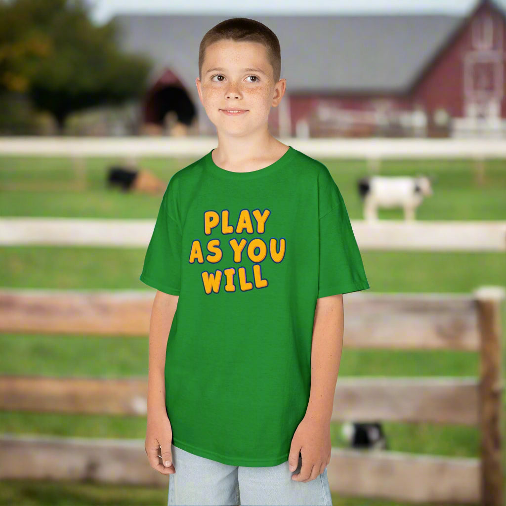 Child wearing a green t-shirt with 'Play as You Will' text on a white background